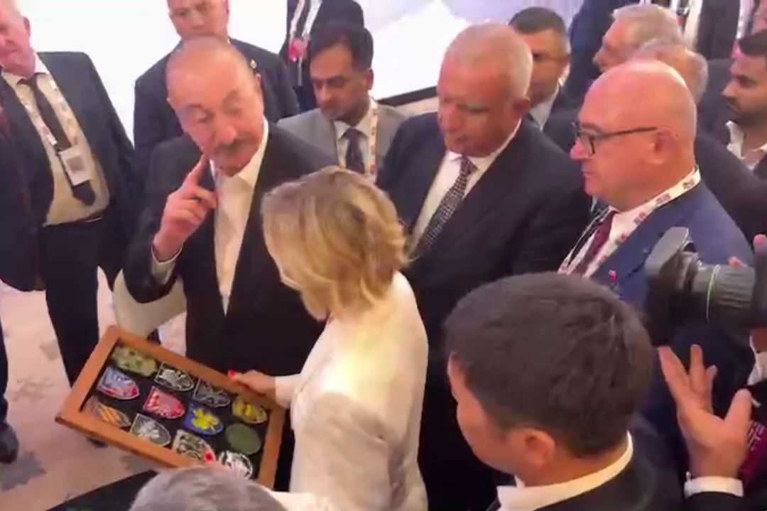 President Ilham Aliyev receiving a collection of military patches from a Ukrainian journalist. Screenshot from video.