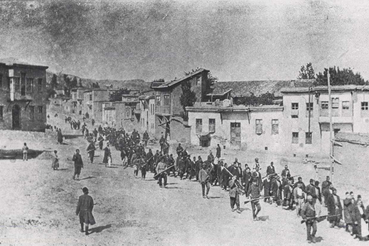 Ottoman military forces lead Aremnian men to an execution site in spring 1915. Photo via Wikimedia Commons.