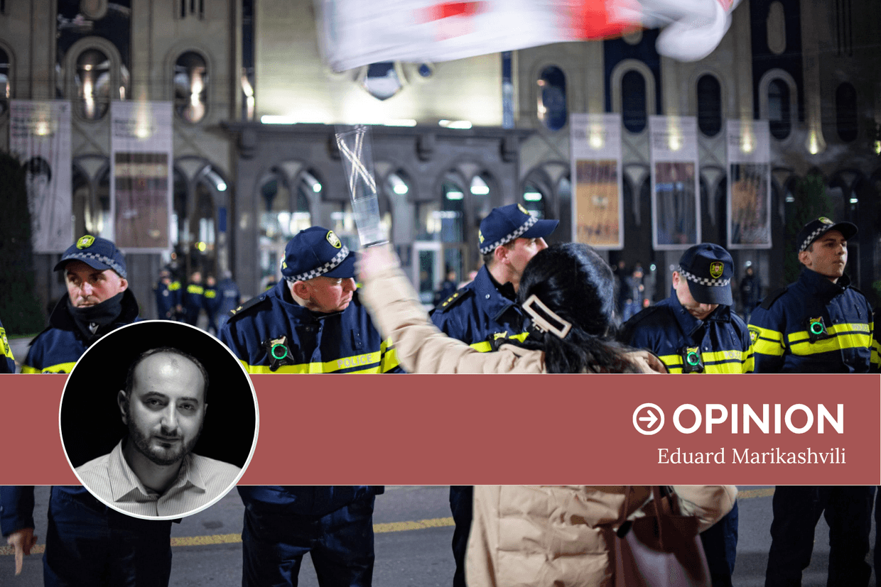A protester waves a Georgian flag in front of a row of police officers on Rustaveli Avenue. Photo: Mariam Nikuradze/OC Media.