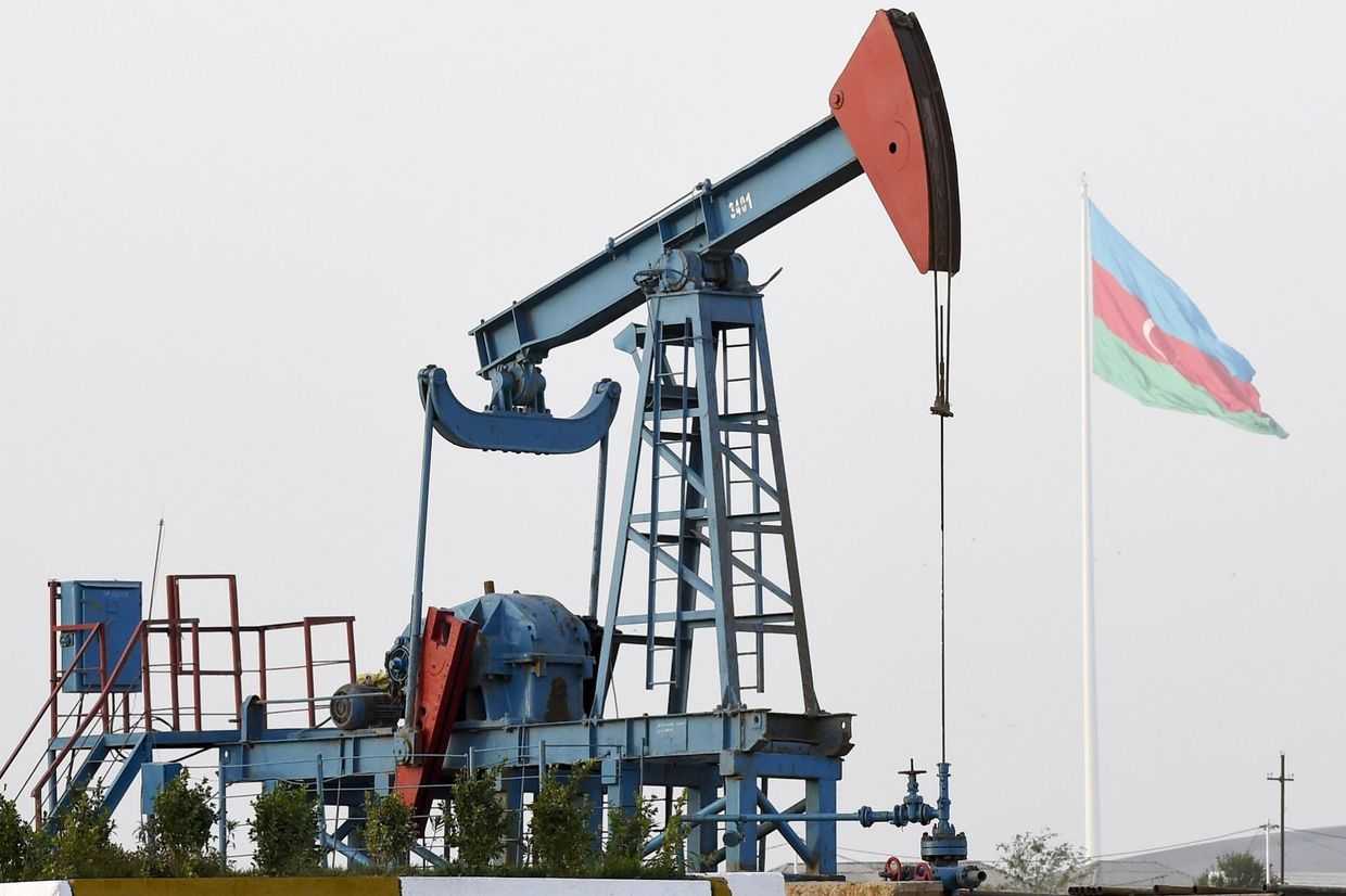 An oil well with the Azerbaijani flag flying in the background. Photo via News.az.