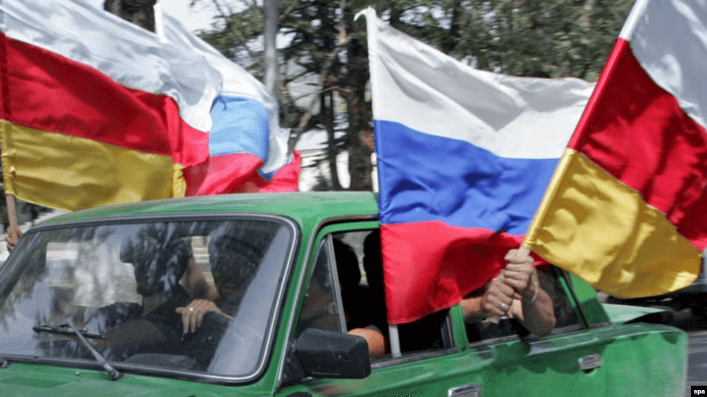 People wave Russian and South Ossetian flags in Tskhinvali (Tskhinval), South Ossetia, after Russia recognised the independence of South Ossetia in 2009. For illustrative purposes. Photo: EPA and RFE/RL.