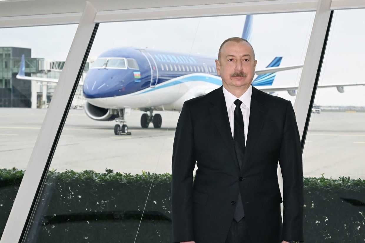 Azerbaijani President Ilham Aliyev stands in front of an Azerbaijan Airlines plane at Baku's Heydar Aliyev Airport. Official image.