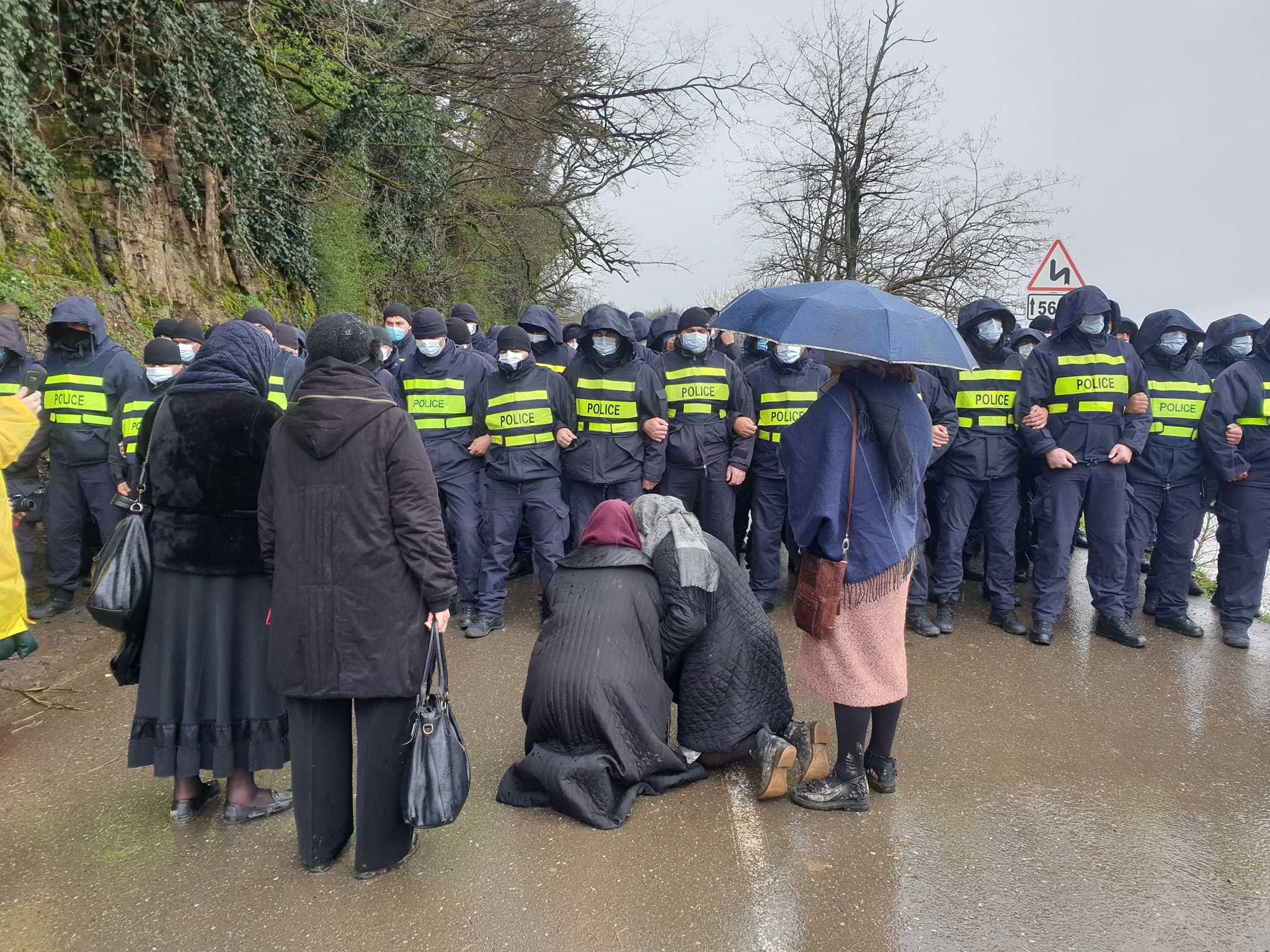 Two women kneel in front of police blocking off the Rioni Valley near the village of Gumati. Photo: Dato Simonia.
