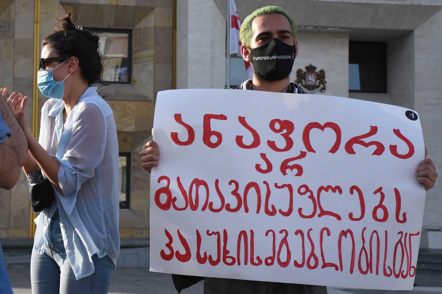 'A protester holding a sign that reads: 'A Priest's robes do not release from responsibility'. Shoshiashvili/OC Media.