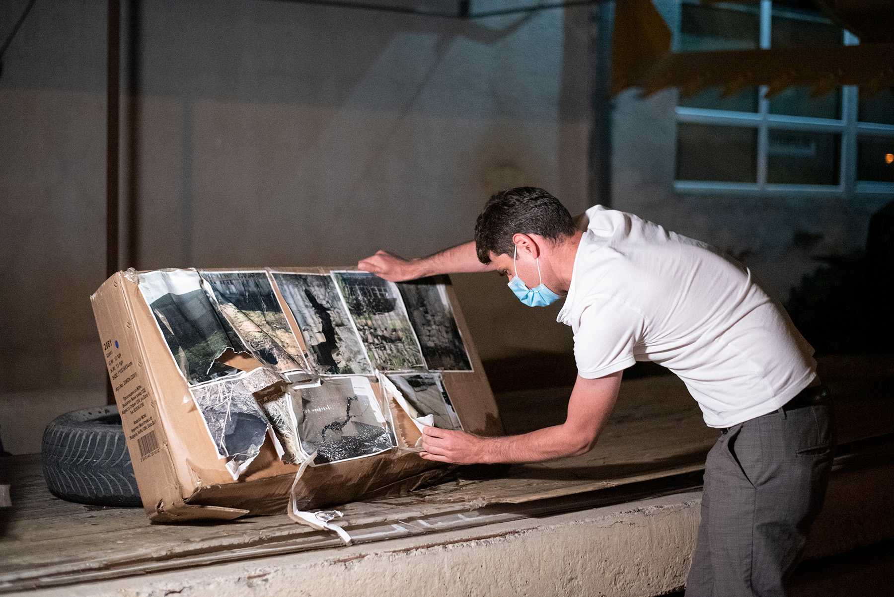 Photos of destroyed houses in Shukruti being taken down from the protest site outside the US Embassy in Tbilisi. Photo: Mariam Nikuradze/OC Media. 