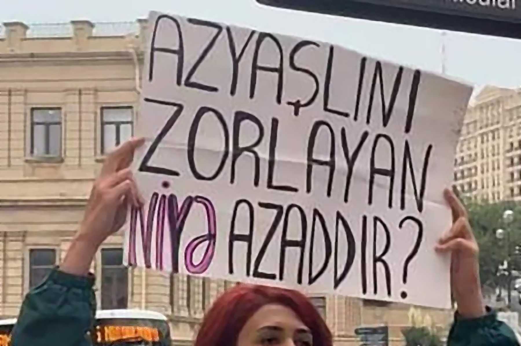 Feminist activist Gulnara Mehdiyeva holding a sign reading 'Why is a person who raped a minor still free?'  Original photo by Sevgi Ismaylbayli.