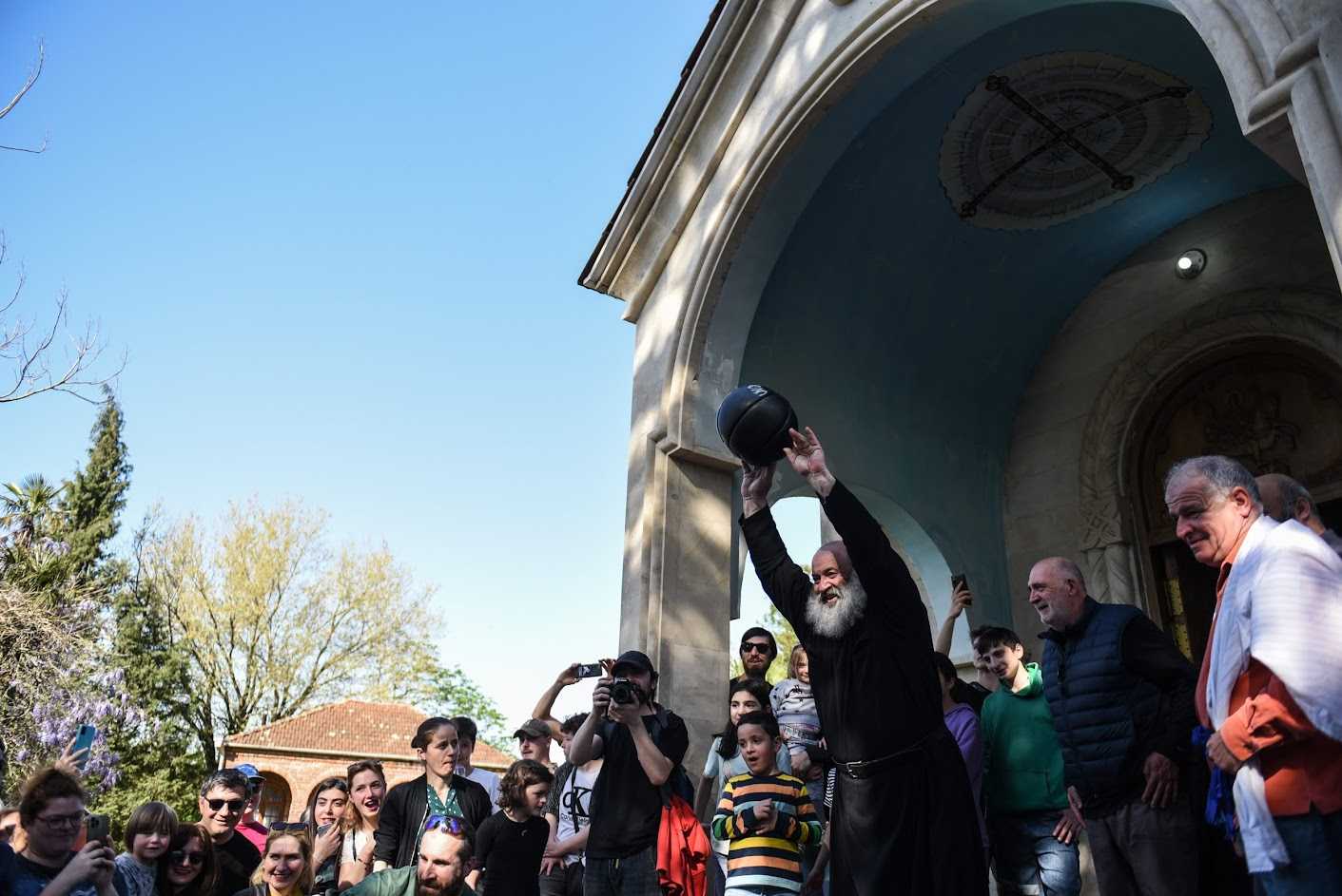 Archpriest Saba demonstrates the heft of the leloburti ball before the game commences. Mariam Nikuradze/OC Media.