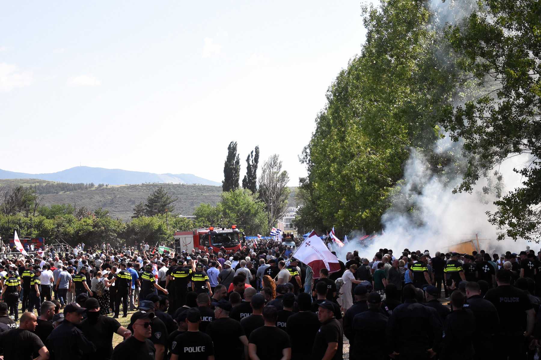 Police watch on as supporters of Alt Info set fire to and destroy the festival grounds. Photo: Tata Shoshiashvili/OC Media.
