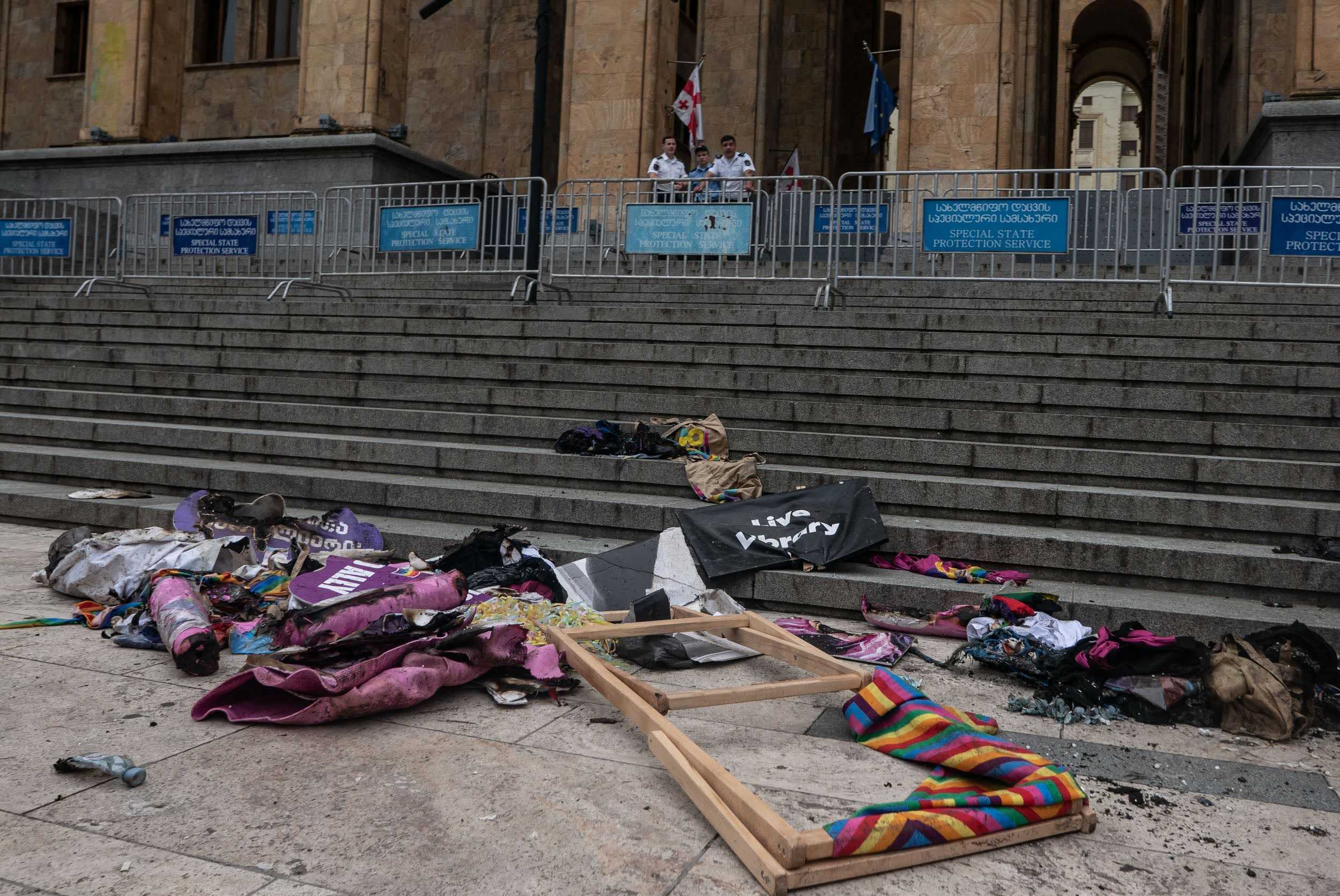 A Tbilisi Pride protest outside the parliament in July 2023, after homophobic groups destroyed the site of a planned Pride festival. Organisers lay items damaged at the site on the steps of Parliament. Photo: Mariam Nikuradze/OC Media