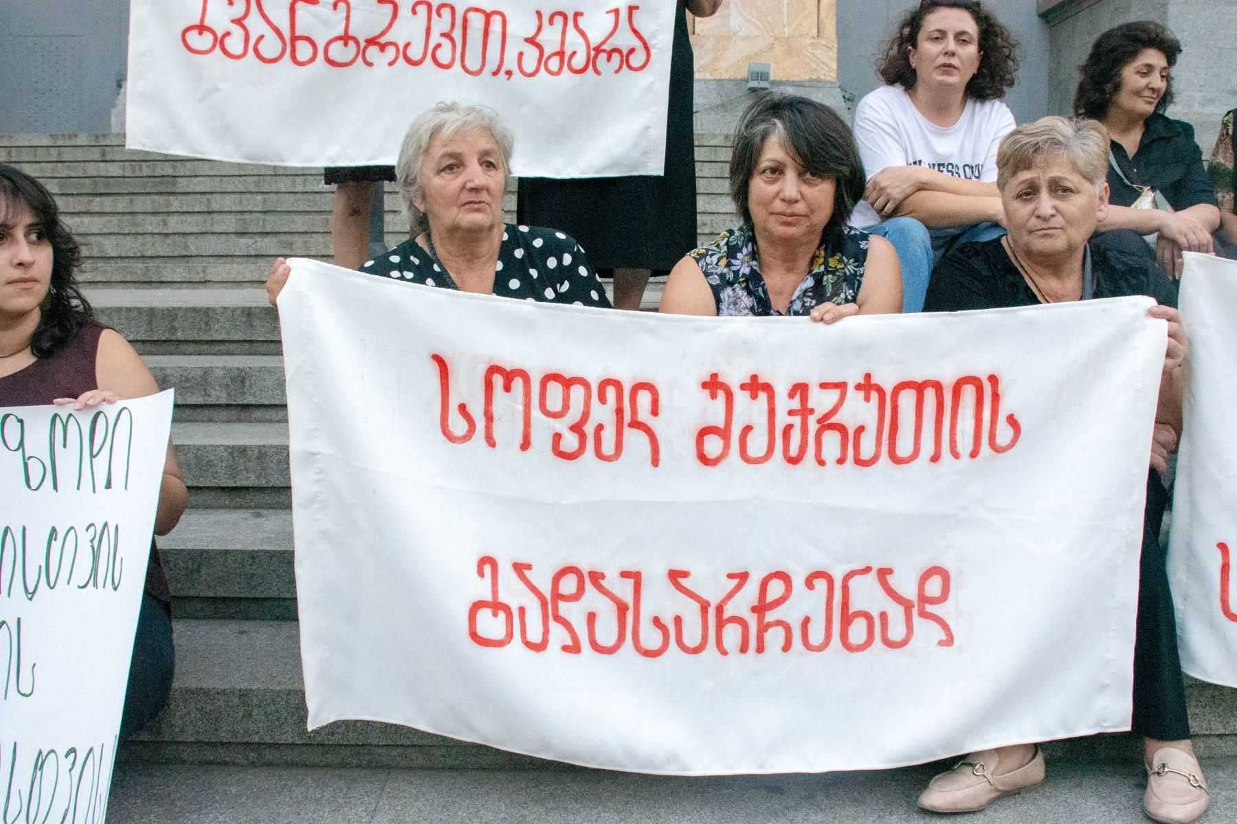 Residents of Shukruti hold a banner saying ‘To save village Shukruti’. Photo: Tata Shoshiashvili/OC Media.