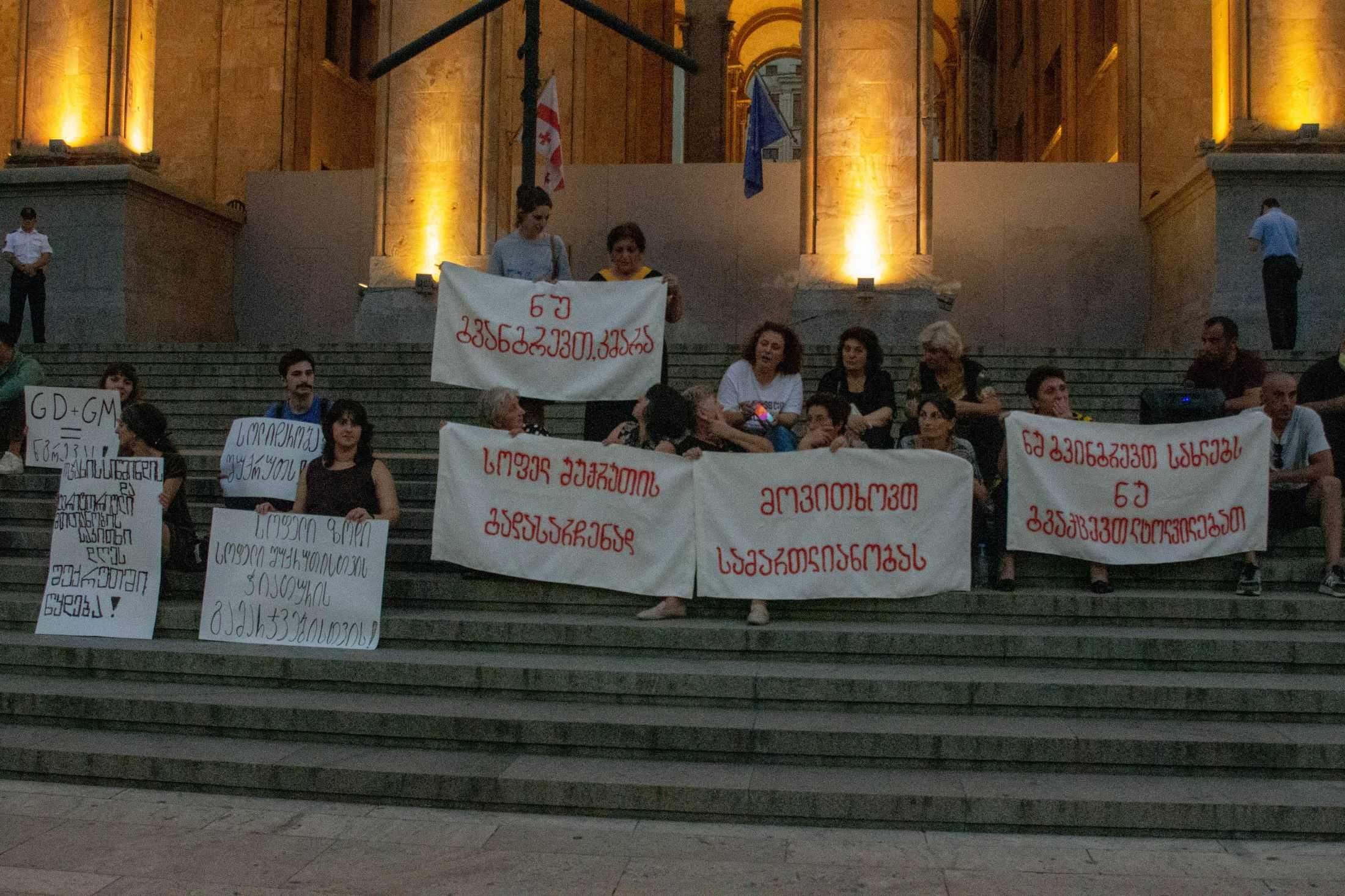 Residents of Shukruti hold banners during the protest in front of the Georgian parliament on 11 September. Photo: Tata Shoshiashvili/OC Media.