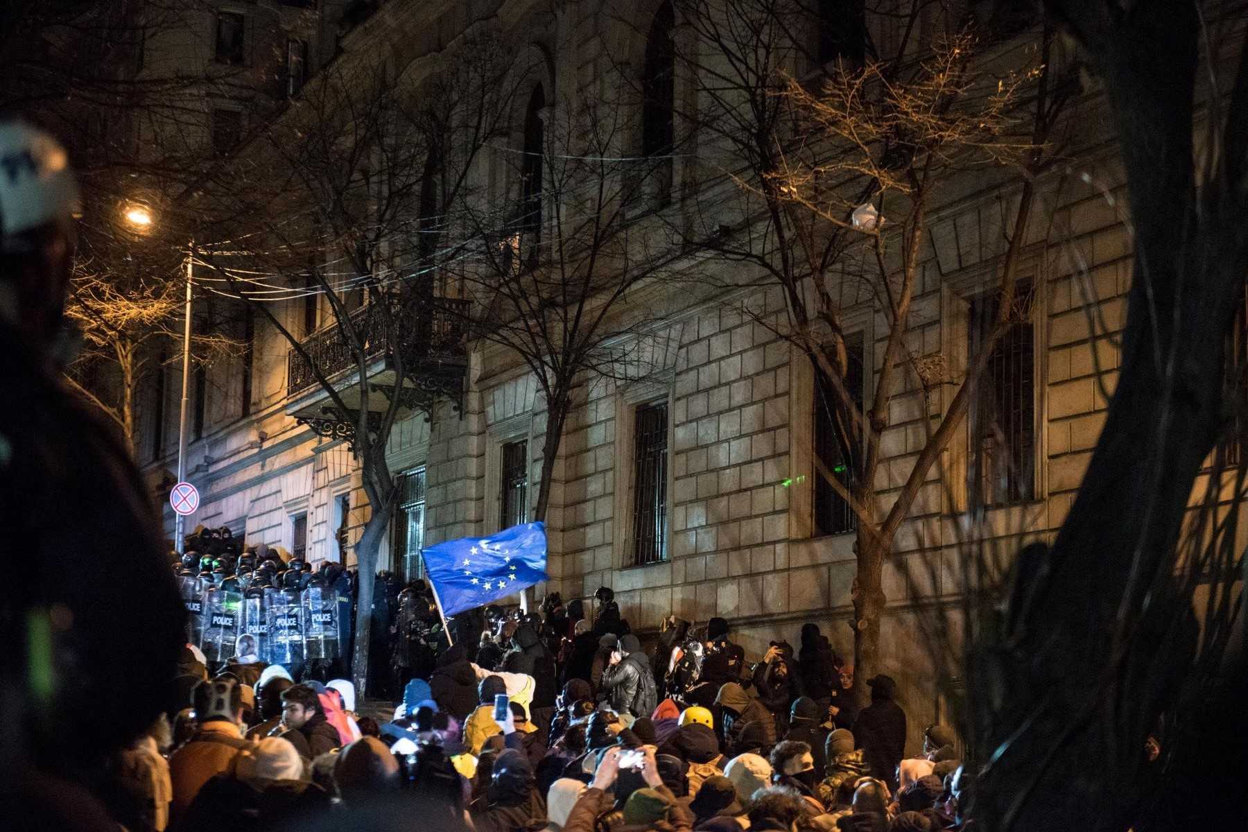 A protester waves the EU flag at riot police during a standoff near the Georgian Parliament. Photo: Mariam Nikuradze/OC Media