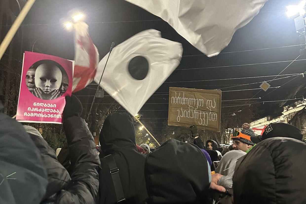 People carry flags symbolising the leaked ink affecting electoral ballots during the parliamentary elections during a protest on Rustaveli Avenue. Photo: Tamar Mchedlidze/OC Media.