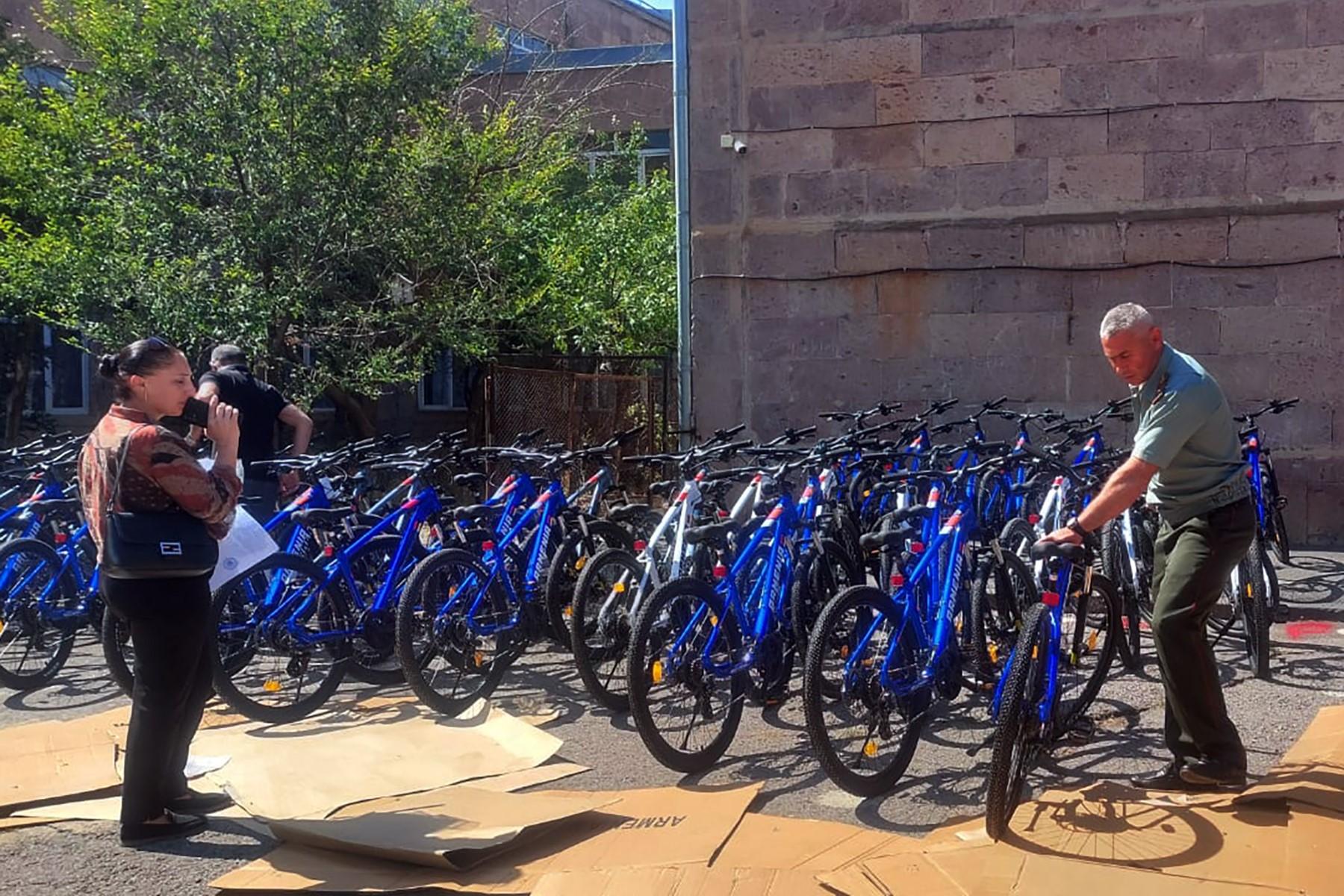 Armenian officials handing over bikes to a school. Official photo.