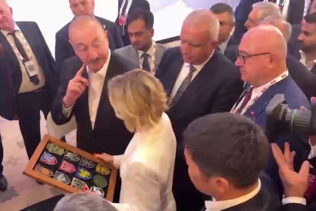 President Ilham Aliyev receiving a collection of military patches from a Ukrainian journalist. Screenshot from video.