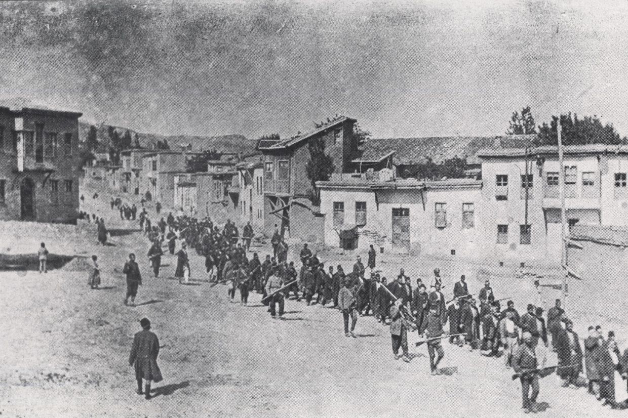 Ottoman military forces lead Aremnian men to an execution site in spring 1915. Photo via Wikimedia Commons.