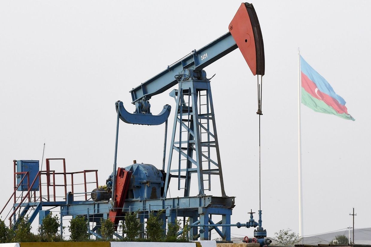 An oil well with the Azerbaijani flag flying in the background. Photo via News.az.