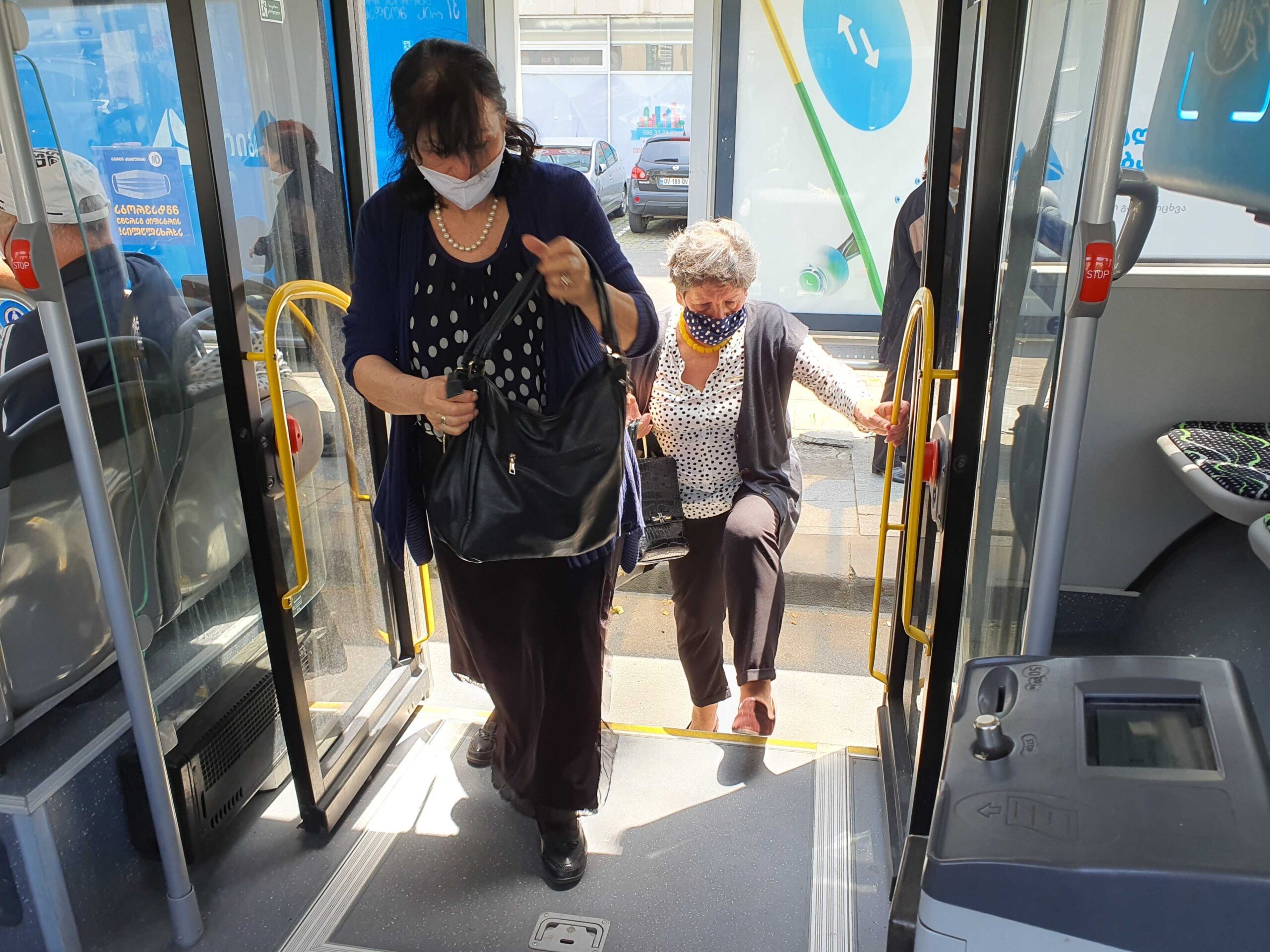 Women in facemasks enter a bus in Tbilisi. Photo: Mariam Nikuradze/OC Media. 