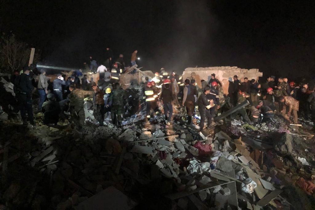 Rescue workers dig through the rubble in Ganja. Image via Hikmet Hajiyev.