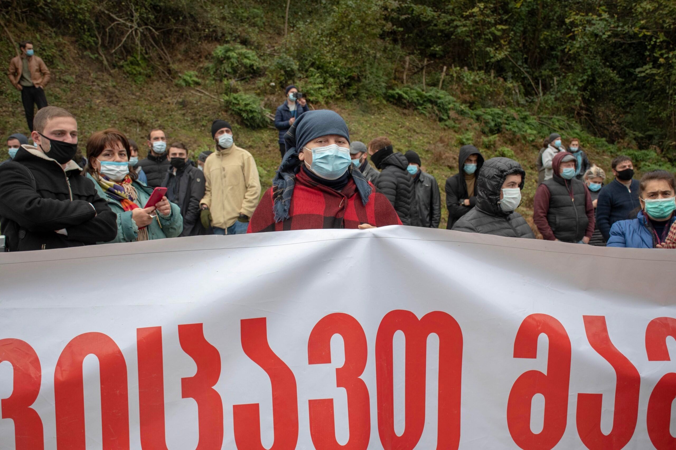 A protester behind the ‘we are defending homeland’ banner in Zhoneti. Image: Shota Kincha/OC Media.