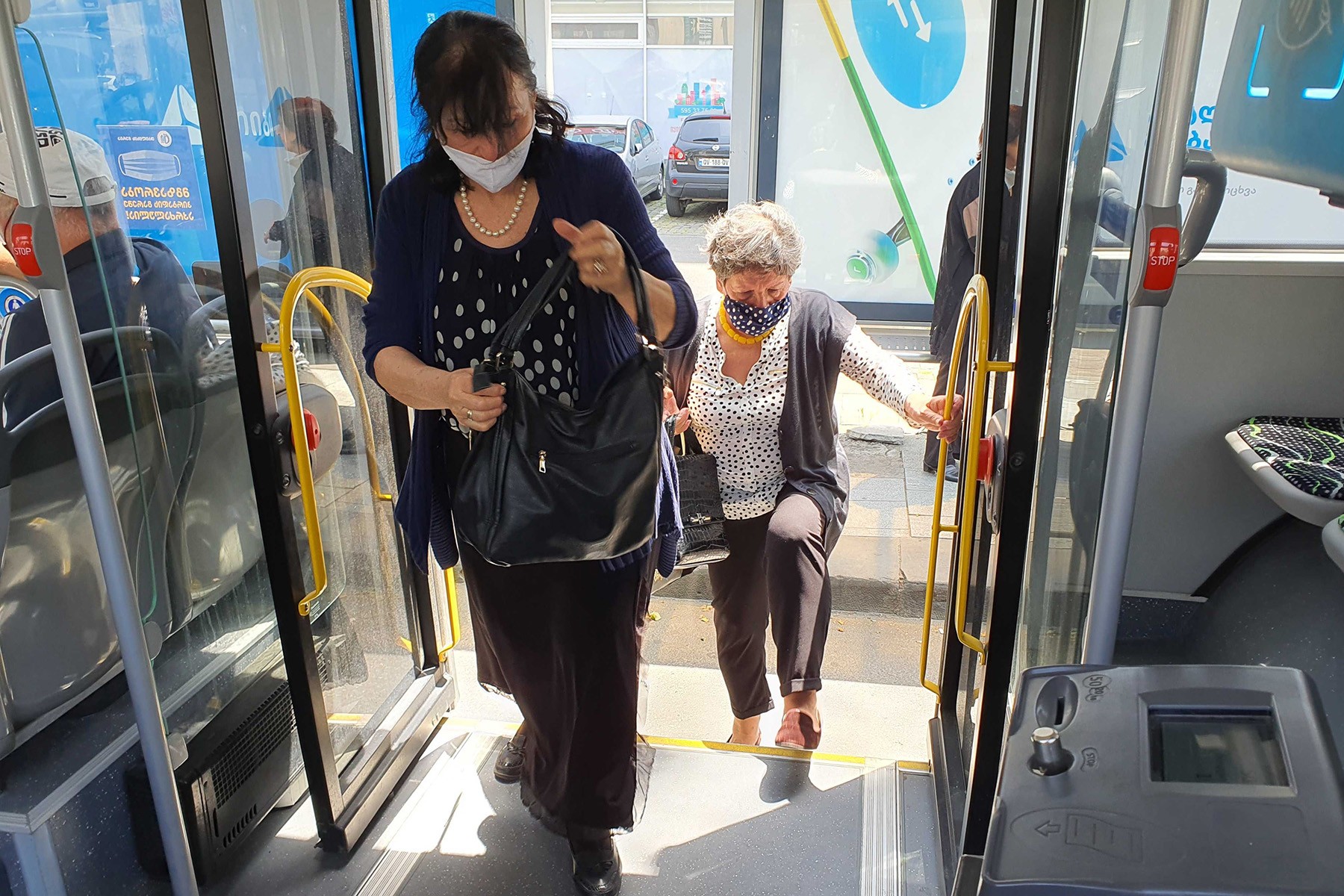 Women in facemasks enter a bus in Tbilisi. Photo: Mariam Nikuradze/OC Media. 