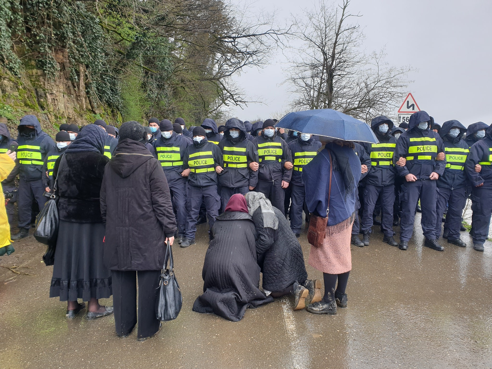 Two women kneel in front of police blocking off the Rioni Valley near the village of Gumati. Photo: Dato Simonia.
