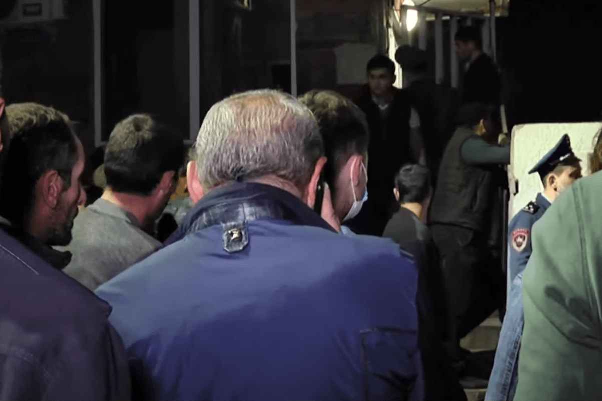 Relatives wait for plane reportedly carrying POWs to land. Video still.