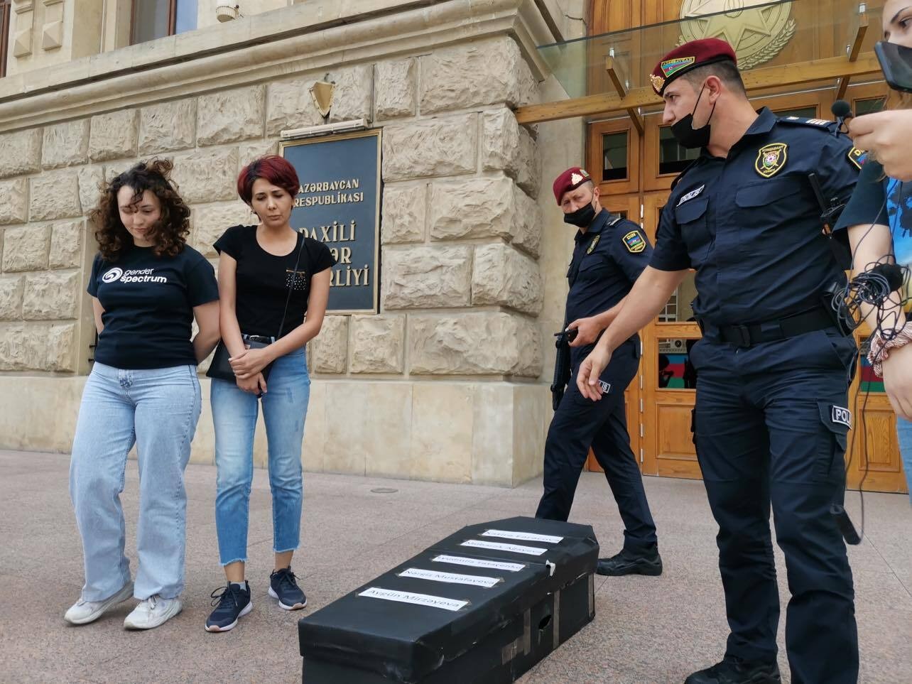 Activists Aytaj Aghazade and Gulnara Mehdiyeva stand next to a coffin with the names of five women murdered in recent weeks. Photo: Abzas.
