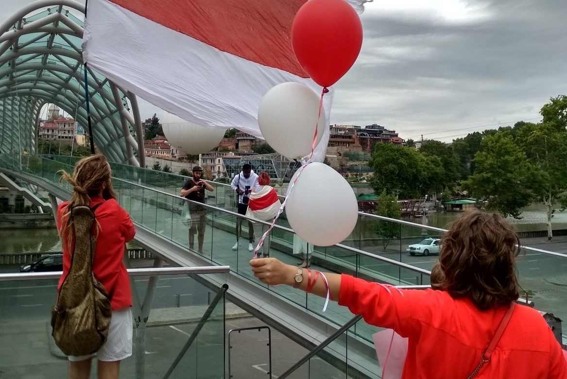 Belarusian activist with unfurled white-red-white stripe flag that Belarusian authorities have effectively banned, in Tbilisi. Image: Belarus Freedom, Georgian Solidarity Facebook page. 