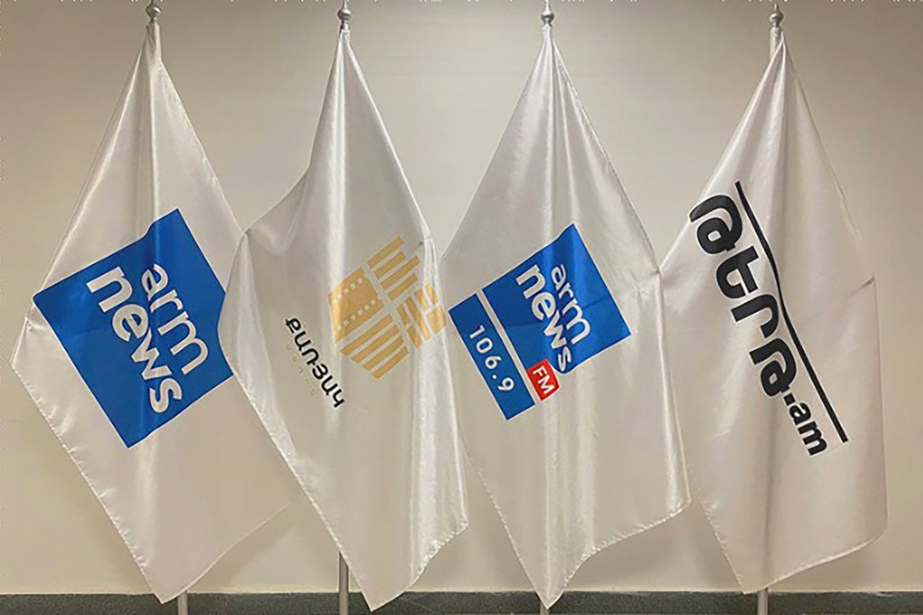 Flags showing various Karyak media holdings. Photo via Arka.am.