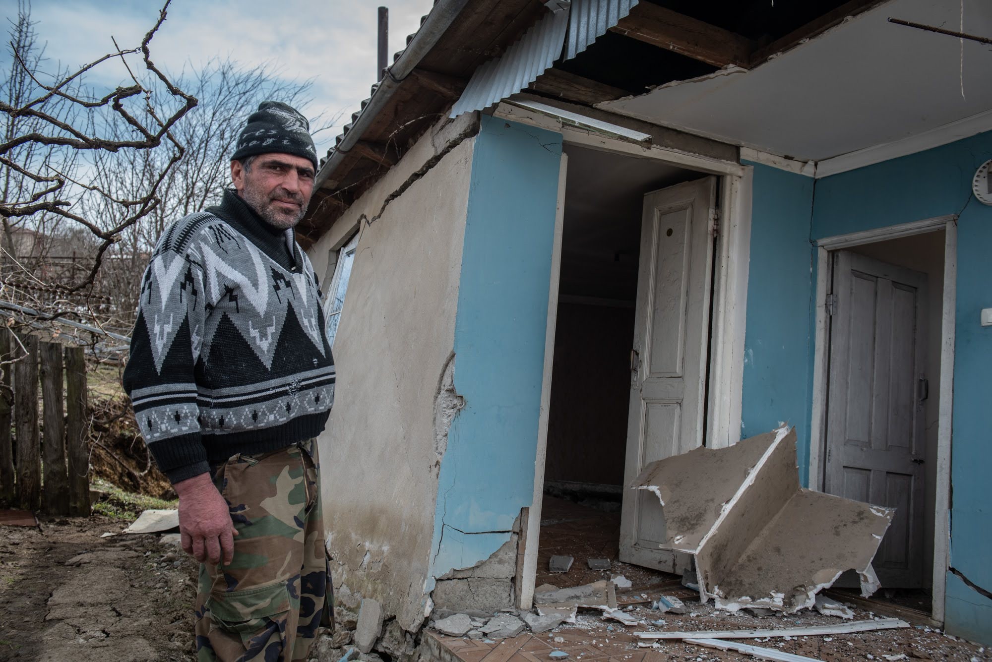 Boris Megrelishvili, a resident of Itkhvisi, shows the damage to his house, which is collapsing into the ground. Photo: Mariam Nikuradze/OC Media. 