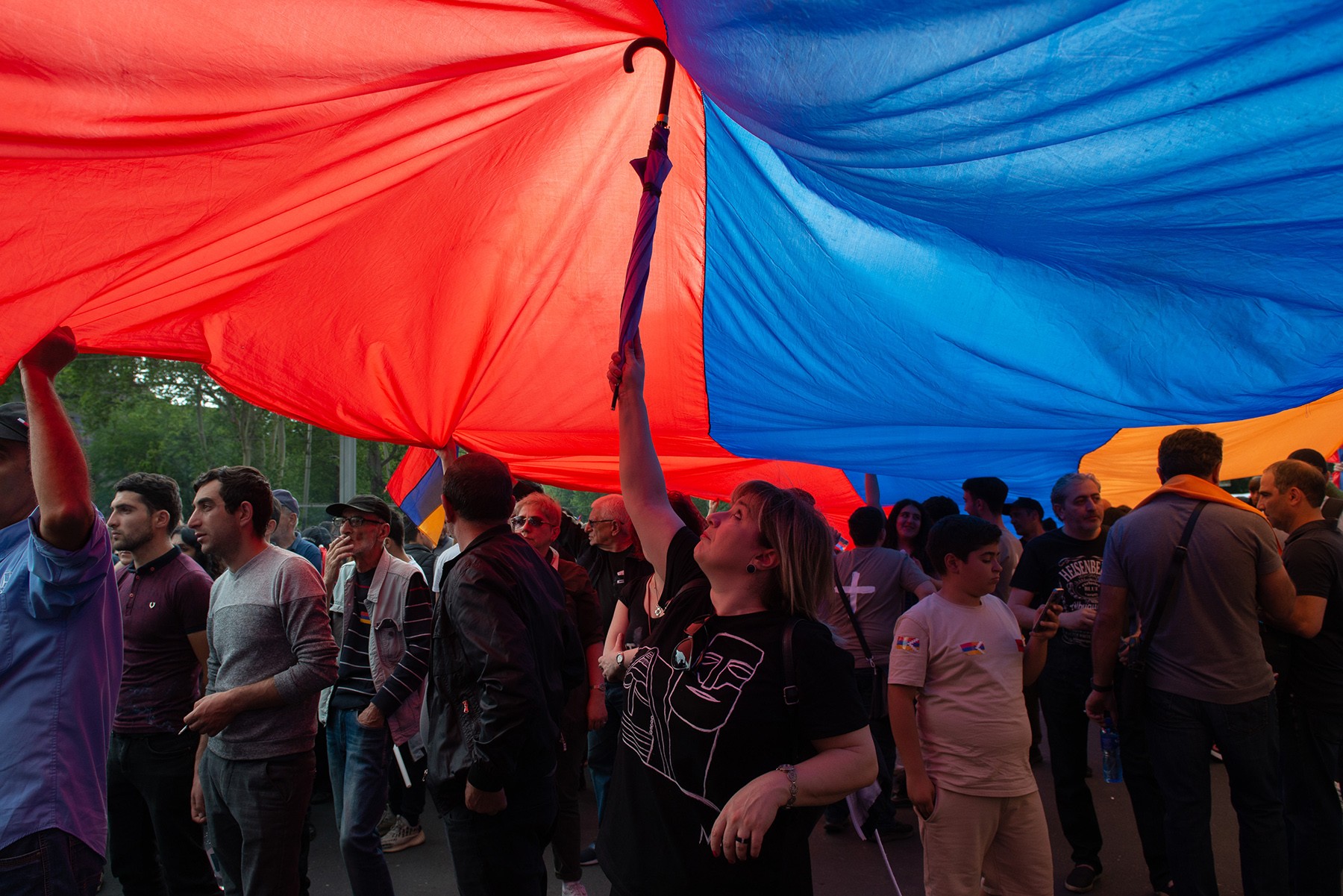 A woman holds helps lift a massive flag of the Nagorno-Karabakh (Artsakh) Republic. Photo: Tamuna Chkareuli.