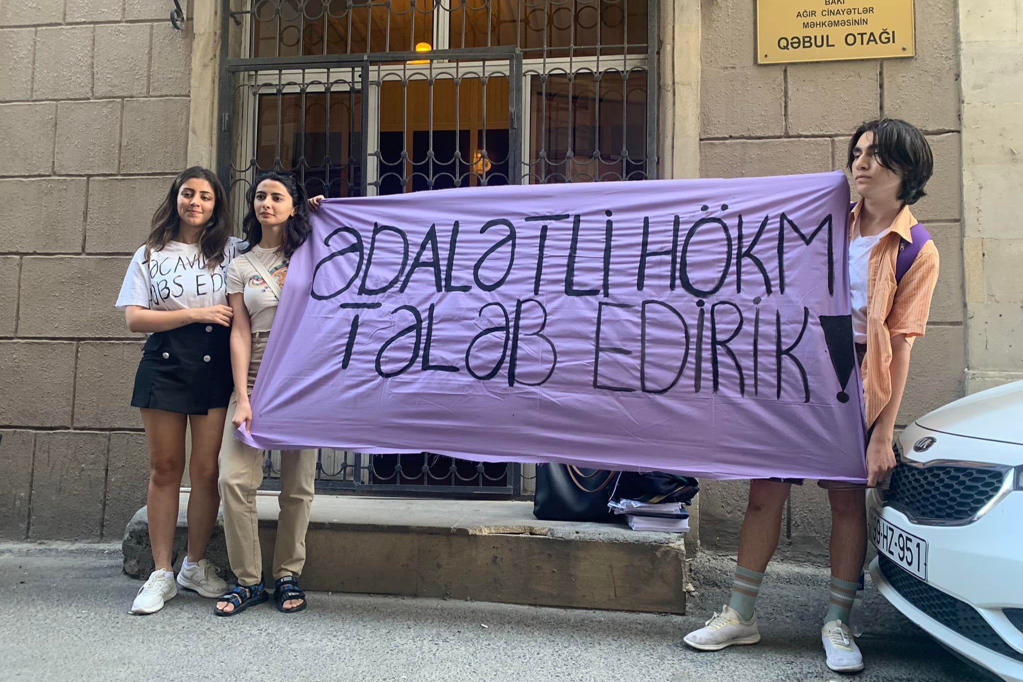 Sanay Yaghmur (left) with two other activists protesting outside the Baku Court of Grave Crimes on 29 June. The banner reads: ‘we demand justice’.