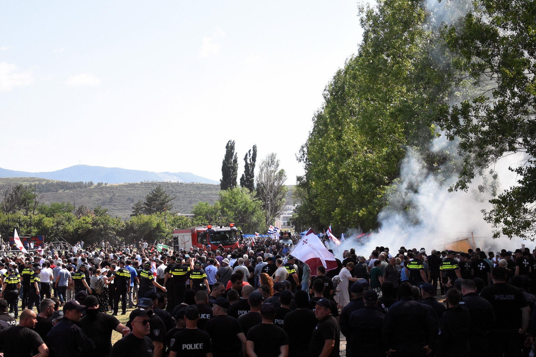 Police watch on as supporters of Alt Info set fire to and destroy the festival grounds. Photo: Tata Shoshiashvili/OC Media.