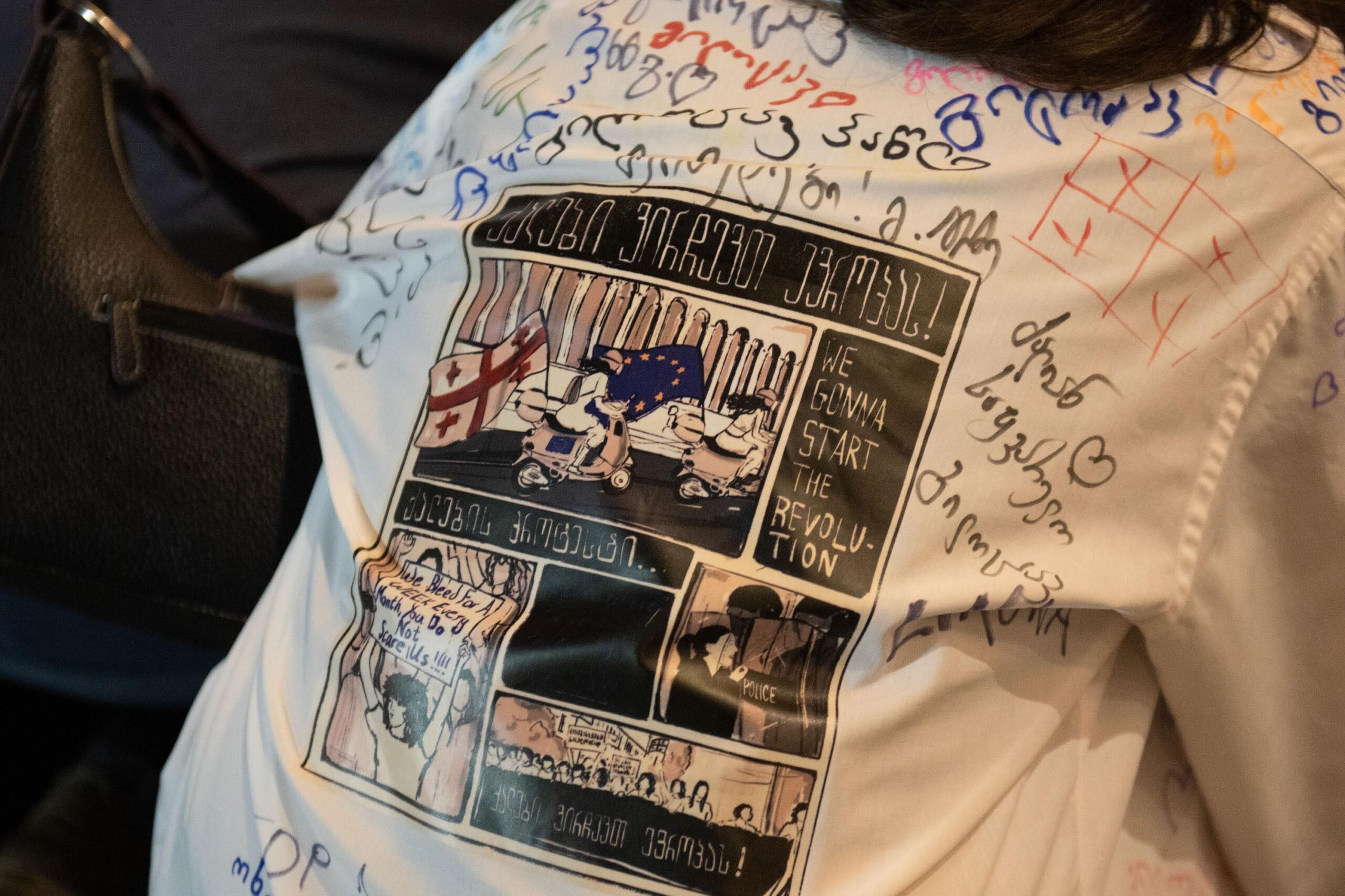 A school leaver wearing a decorated school shirt at a protest against the Foreign Agent Law on Monday. Photo: Mariam Nikuradze/OC Media 