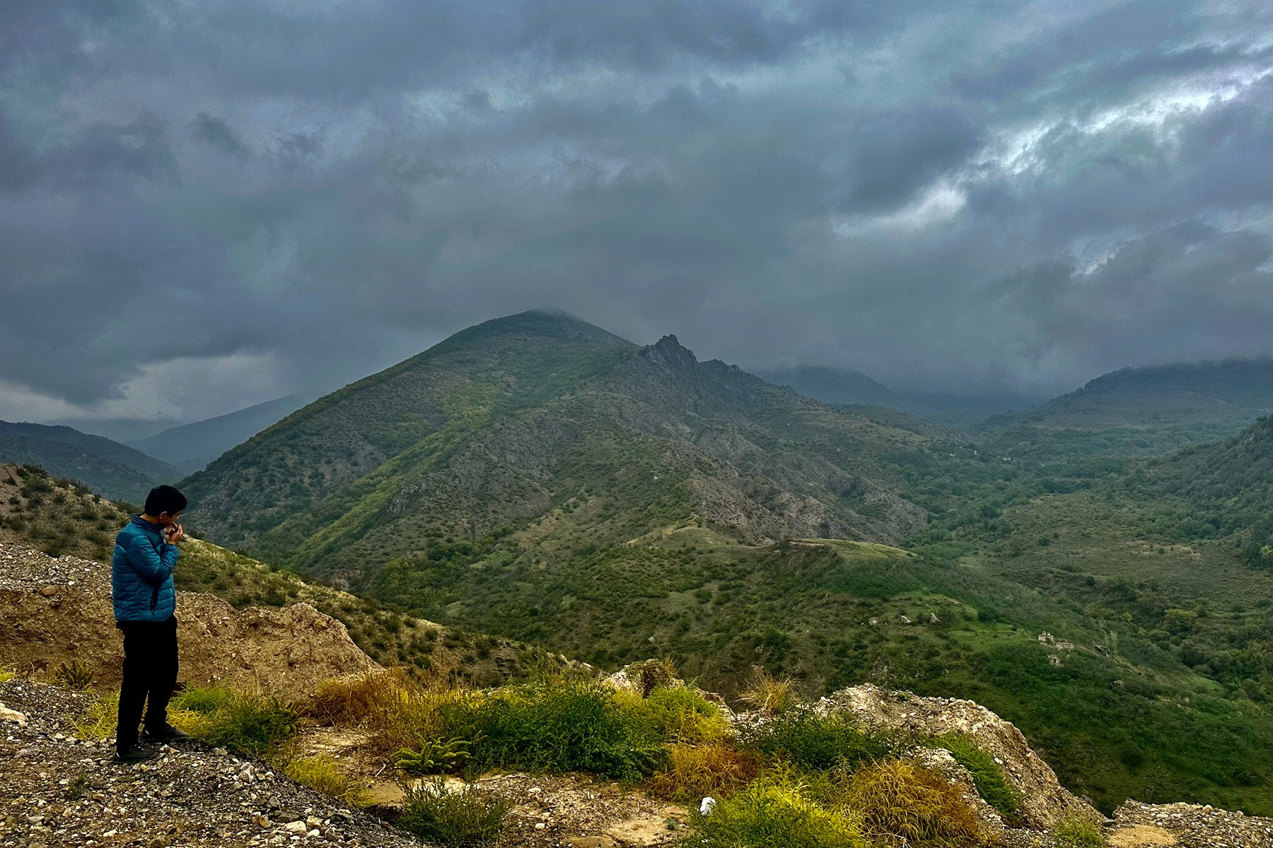 A young man stares out at the mountains of Nagorno-Karabakh during the mass exodus to Armenia in October 2023. Photo: Marut Vanyan/OC Media.