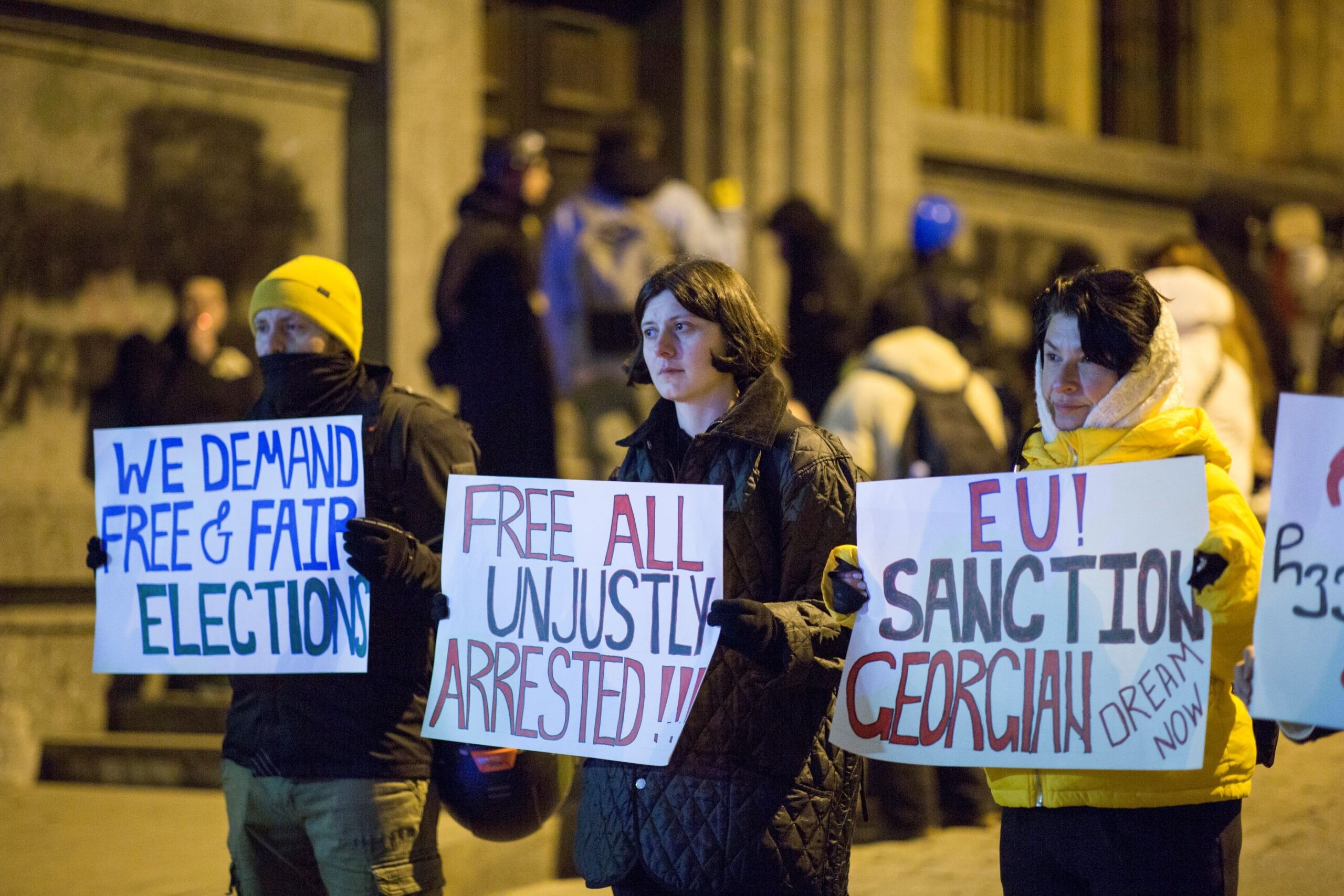 Tamara Jobava (centre) and her friends hold signs callling for EU sanctions and the release of detained protesters during a pro-EU rally in Tbilisi. Photo courtesy of Irakli Sabekia. 