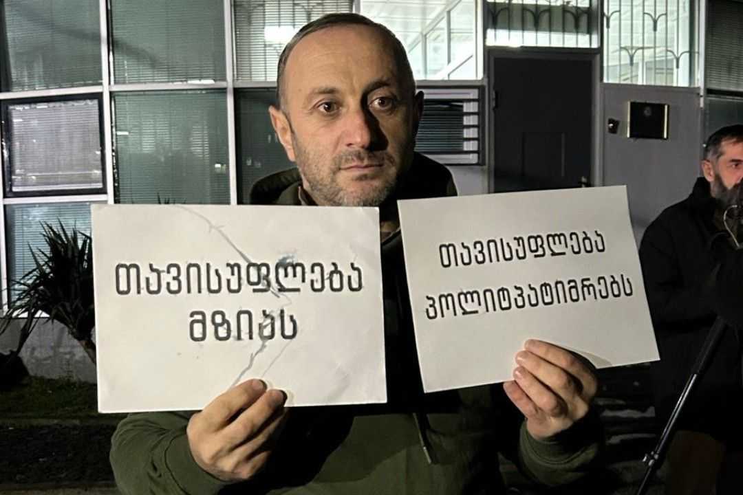 Guram Murvanidze, after his release, holding posters that read ‘Freedom for Mzia’ and ‘Freedom for political prisoners’. Photo: Batumelebi