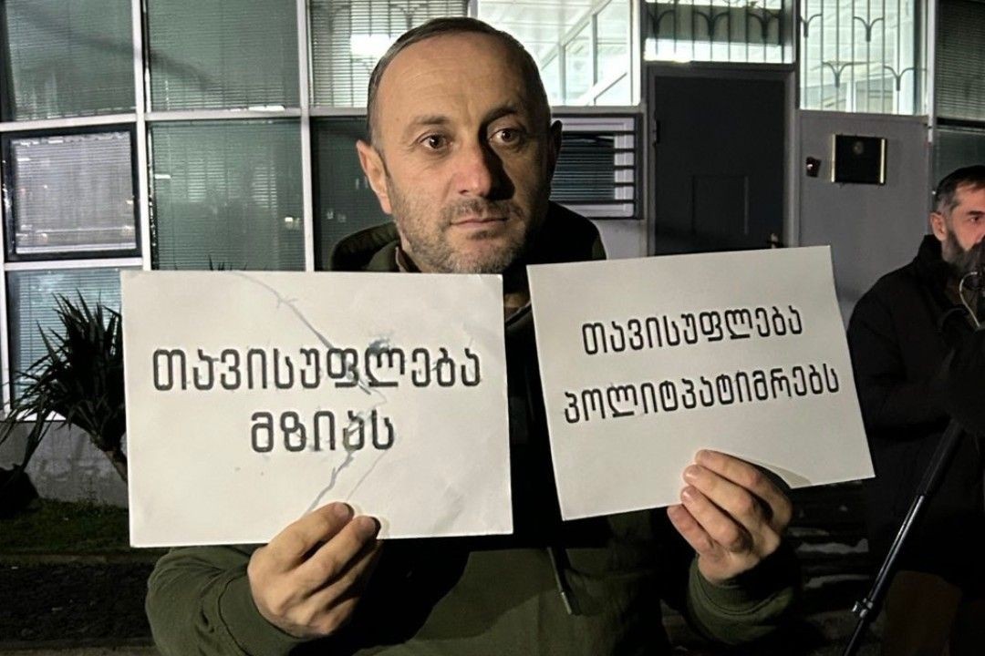 Guram Murvanidze, after his release, holding posters that read ‘Freedom for Mzia’ and ‘Freedom for political prisoners’. Photo: Batumelebi