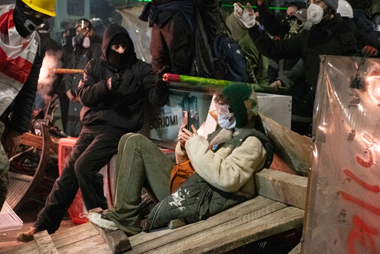 A protester uses their phone at a barricade in the early days of the anti-government and pro-EU protests in Tbilisi. Photo: Mariam Nikuradze/OC Media.