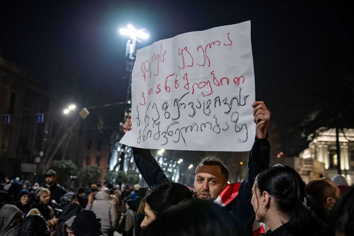 Lasha Jioshvili holds a banner saying: ‘Today, we all agree on the importance of condoms’. Photo: Mariam Nikuradze/OC Media.