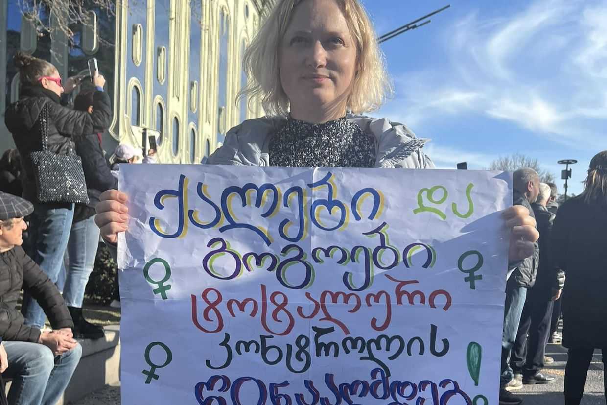 Regina Jegorova-Askerova at a rally against the foreign agents law in Tbilisi holding a poster reading ‘Women and girls against total control’. Courtesy photo.