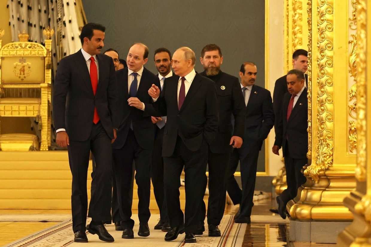 Qatari Emir Tamim bin Hamad Al Thani (far left) speaks with Russian President Vladimir Putin (centre) while Chechen Head Ramzan Kadyrov stands in the background (to the right behind Putin). Official photo.