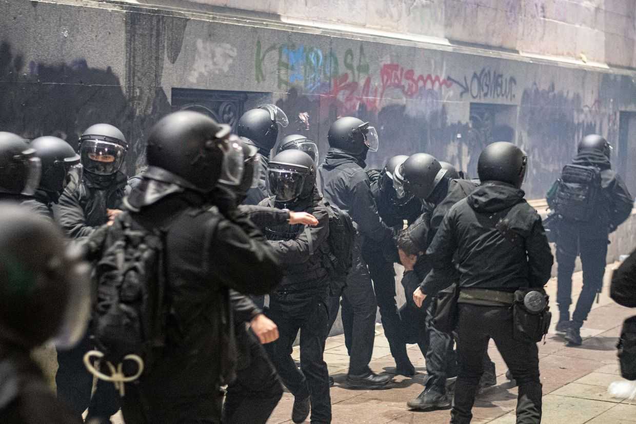 A man covers his eye while behind held by police during a protest dispersal in December 2024. Photo: Mariam Nikuradze/OC Media.