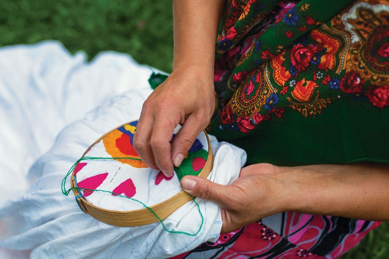An Adjarian woman embroiders in her garden. Official photo.