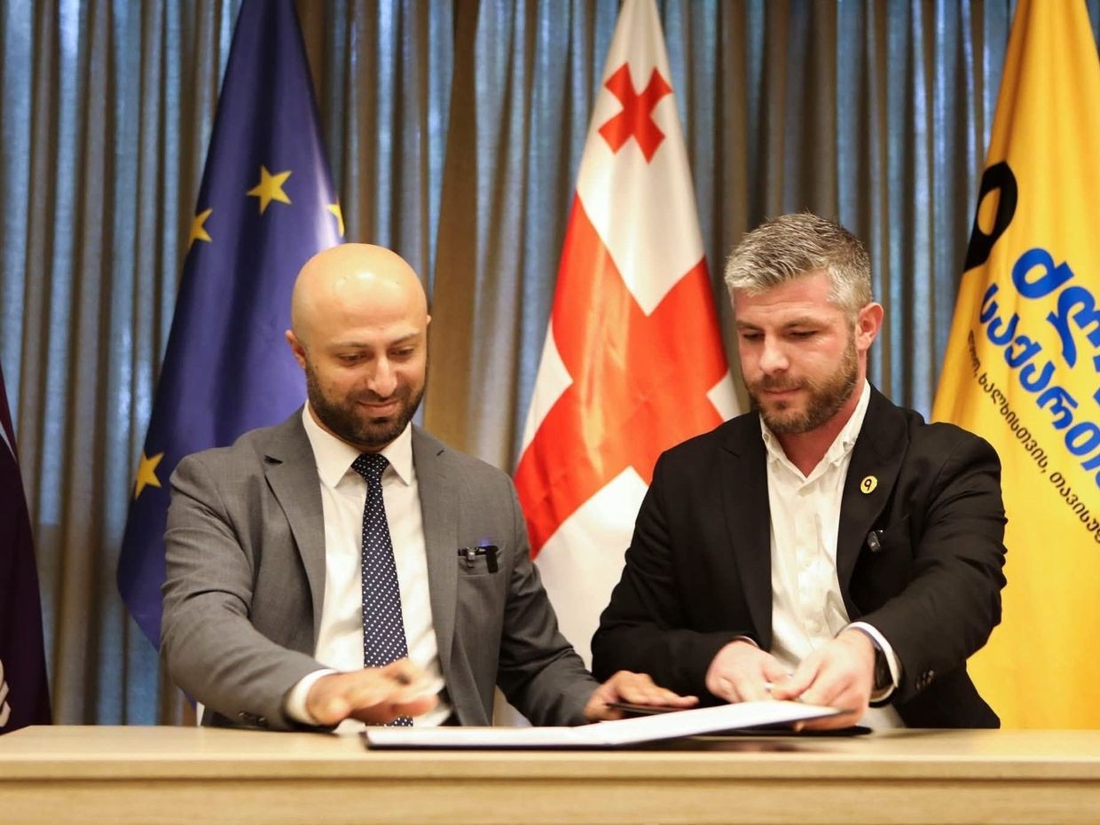 Berdia Sichinava (left) and Irakli Kupradze (right) sign an electoral cooperation pact. Official photo. 