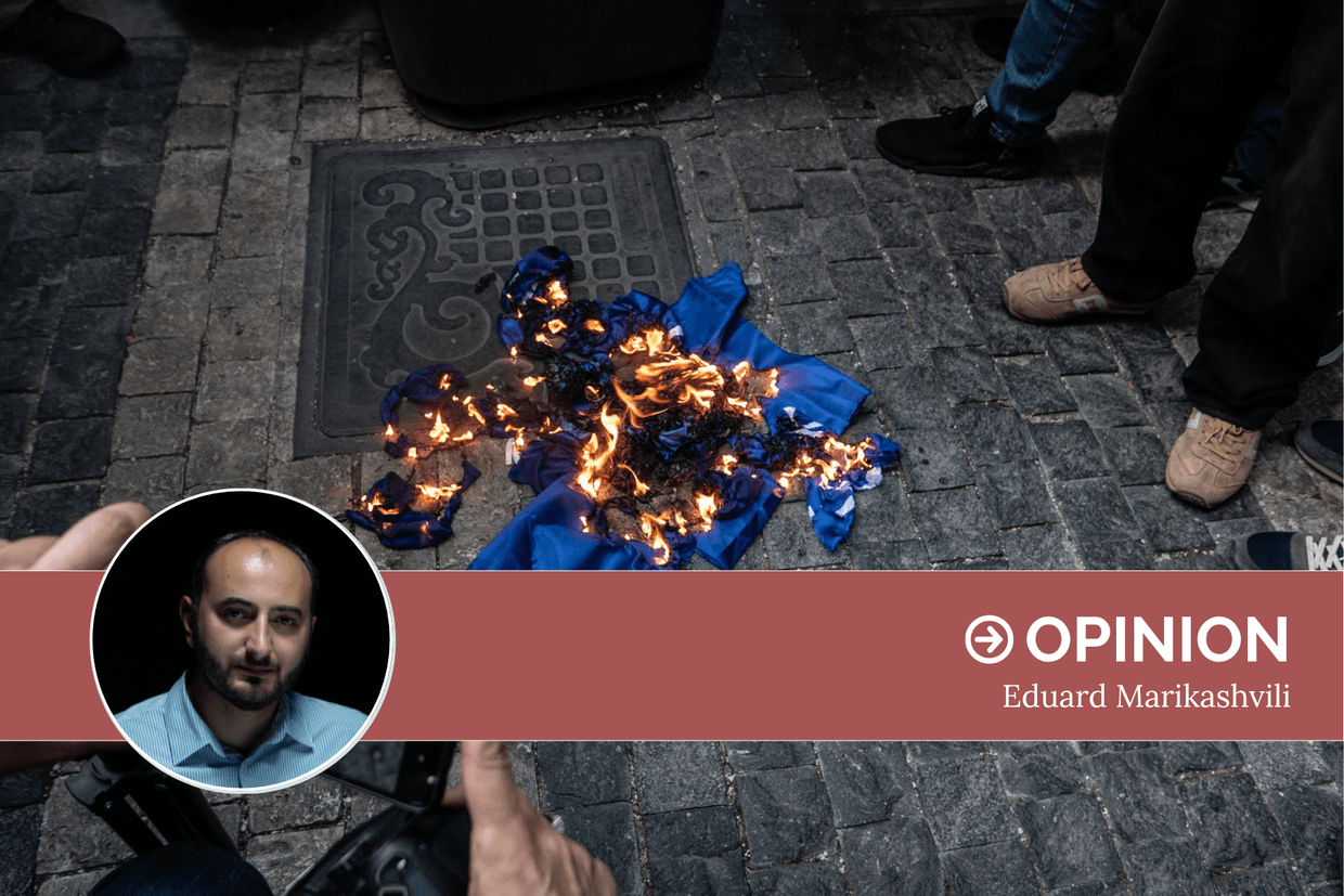 Far-right activists burn the flag of Europe hanging outside the Georgian Parliament on 2 July 2022. Photo: Mariam Nikuradze/OC Media.