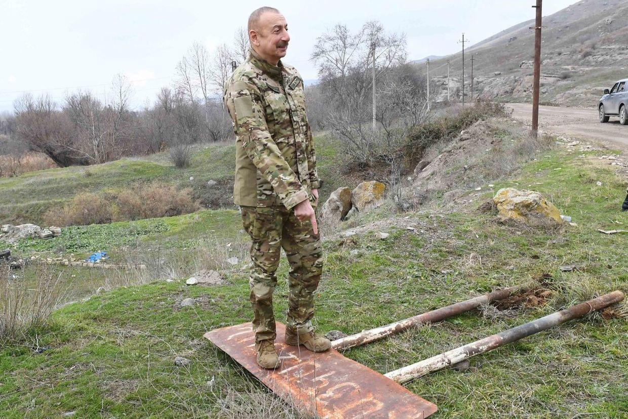 Azerbaijani President Ilham Aliyev stands on an Armenian sign while visiting the Gubadly district in December 2020. Photo via Wikimedia Commons.
