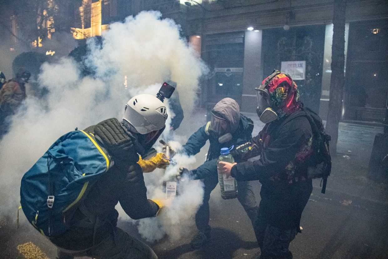Protesters wearing protective gear neutralise a gas canister at a rally in Tbilisi. Photo: Mariam Nikuradze/OC Media.