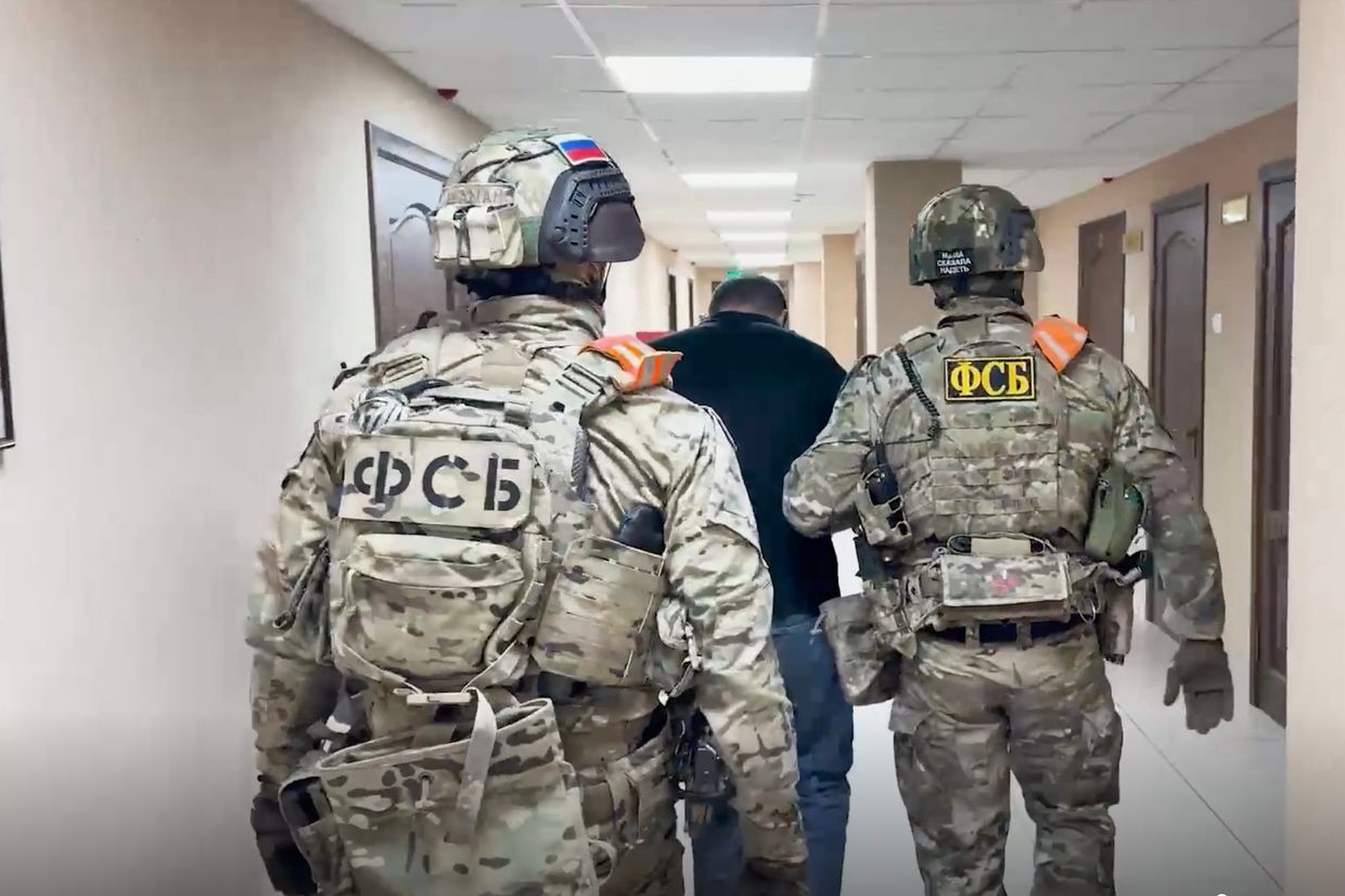 Officers from Russia’s Federal Security Service (FSB) leading away the detained Azerbaijani individual. Screengrab from video from TASS.